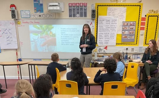 A female engineer showing school children a water activity