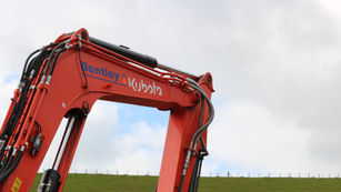 JN Bentley excavator boom against cloudy skies