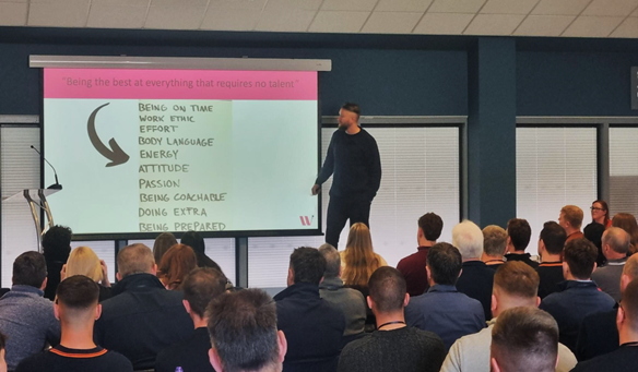 A group of people listening to a man presenting